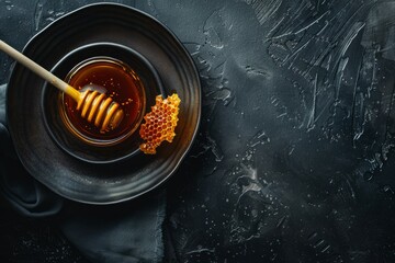 Higos negros y una cuchara con mermelada de higos en un plato negro sobre fondo oscuro. Vista superior