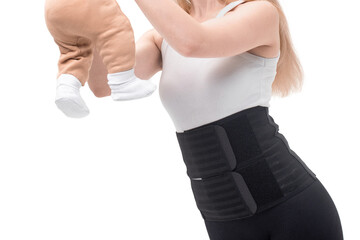 After giving birth, a woman wears a medical belt to support her abdomen and pelvis while holding her baby. Isolated on white background.