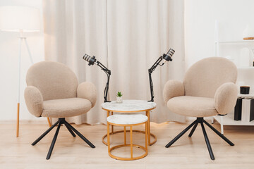 A table and two chairs are prepared for creating a podcast. Cozy atmosphere.