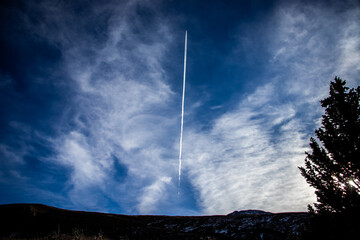 Plane leaving behind a trail as it flies through the sky
