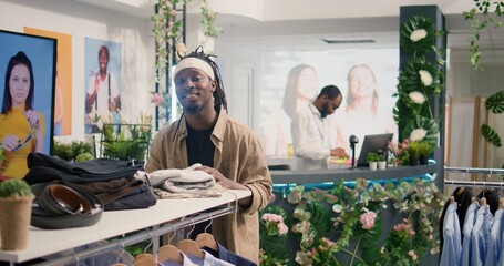 Portrait of client shopping in luxurious clothing store with elegant assortment of blazers....