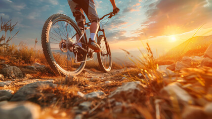 A mountain biker riding on a rocky trail during a stunning sunset, showcasing outdoor adventure and...