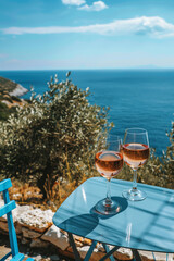 Rose wine in glasses on a table overlooking the sea