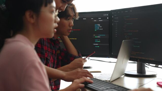 Slow motion back end software developer engineer for computer programming working together on debugging writing computing code, solving complex algorithms display on monitor in office. Burgeoning