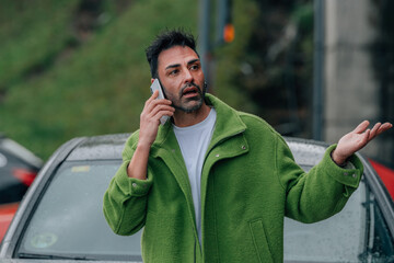 bearded man outdoors with mobile phone in the car