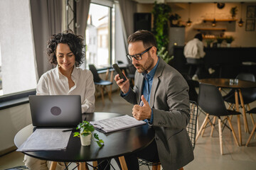 Two colleagues man and woman work together at cafe or restaurant