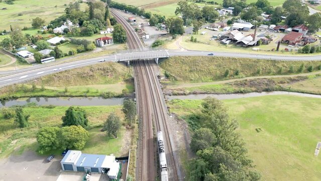 Passenger train going under bridge with traffic