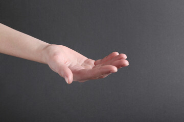 Woman holding hand on black background, closeup
