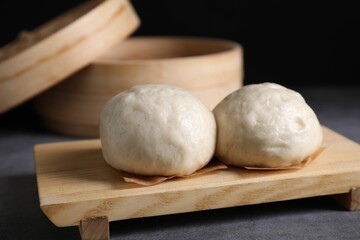 Delicious Chinese steamed buns on grey textured table, closeup