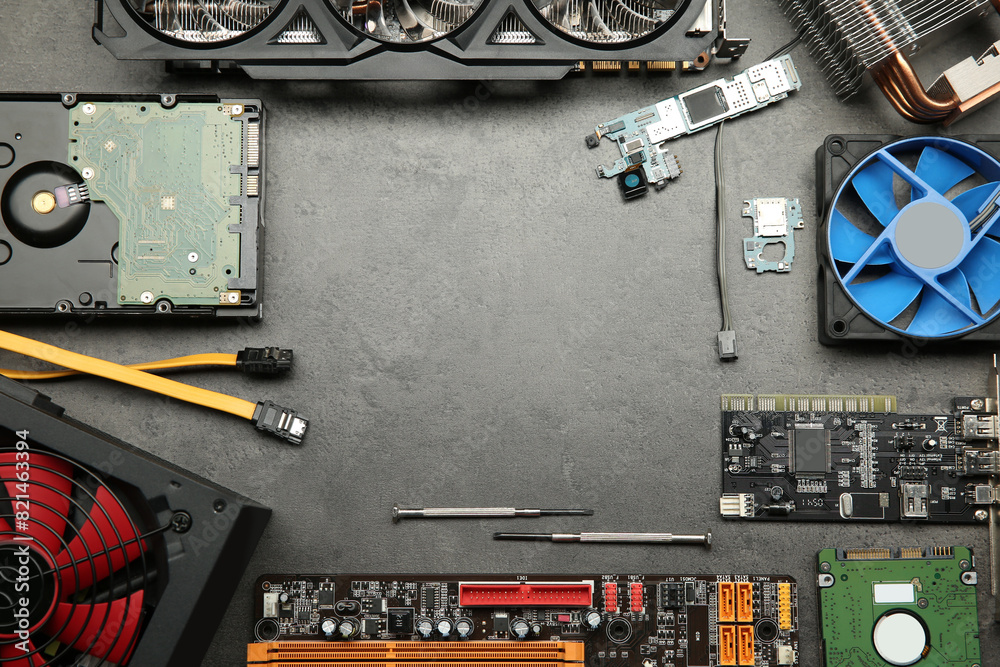Fototapete frame of graphics card and other computer hardware on grey textured table, flat lay. space for text