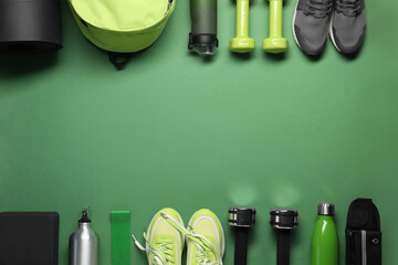 Frame made of different sports equipment on green background, flat lay. Space for text