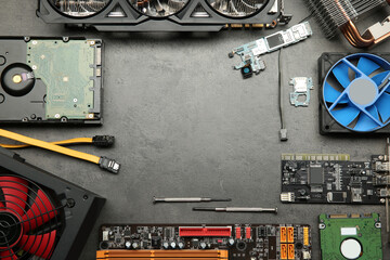 Frame of graphics card and other computer hardware on grey textured table, flat lay. Space for text