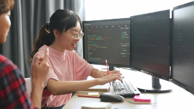 Slow motion back end software developer engineer for computer programming working together on debugging writing computing code, solving complex algorithms display on monitor in office. Burgeoning