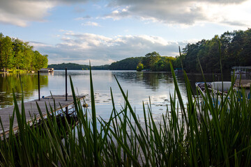 Looking out onto a Wisconsin northwoods lake as the last rays of sunlight begin to fade.  Many pontoon boats have returned from fishing for the evening.