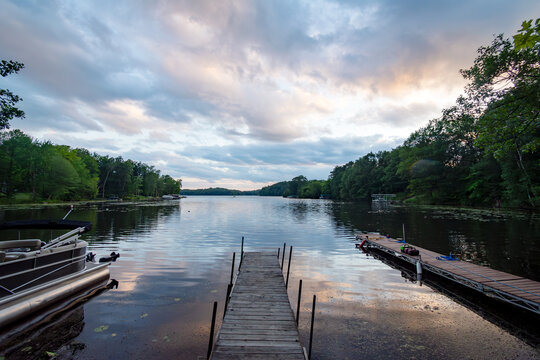 Looking out onto a Wisconsin northwoods lake as the last rays of sunlight begin to fade. Many pontoon boats have returned from fishing for the evening.