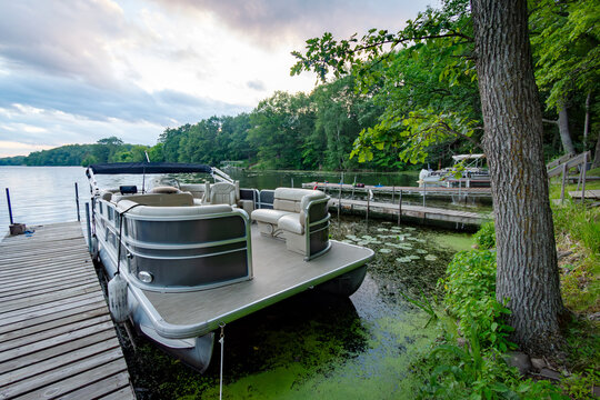 Looking out onto a Wisconsin northwoods lake as the last rays of sunlight begin to fade.  Many pontoon boats have returned from fishing for the evening.