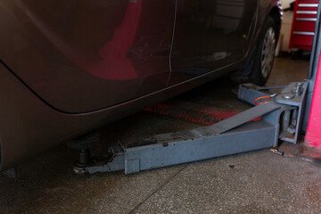 Car lift under a car for under the bottom of a car. The car is top notch. mechanical tools for car...