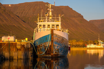 Old oak fishing boat resting at the pier of Flateyri in the Icelandic westfjords