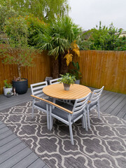 Stylish summer exterior concept with modern house. View of a stylish outdoor wooden floor patio with fantastic forest view. Minimalistic English garden