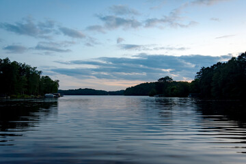 Looking out onto a Wisconsin northwoods lake as the last rays of sunlight begin to fade.  Many boats have returned from fishing for the evening