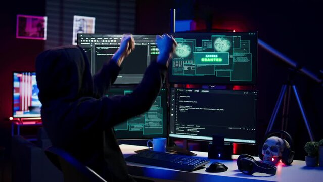 Hacker happy after successfully doing computer sabotage using ransomware, seeing access granted message. Cybercriminal successfully gaining access to victim data, demanding ransom money, camera B