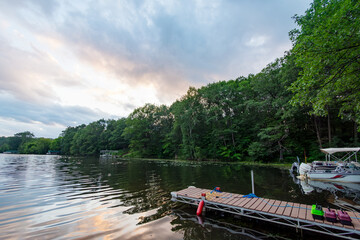 Fototapeta premium Looking out onto a Wisconsin northwoods lake as the last rays of sunlight begin to fade. Many boats have returned from fishing for the evening.