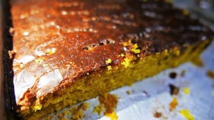 Dessert time. A close-up shot of a big cake pan. Carrot cake with chocolate icing on the top. A pan of pie. 