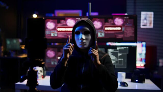Focus on camera on phone on tripod used by hacker concealing identity filming ransom video in hidden base. Close up of smartphone used by cybercriminal with mask to record blackmail footage, camera B