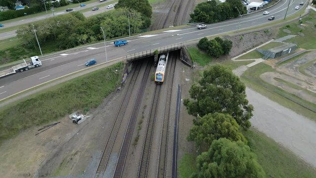 Train passing under the overpass into the city.