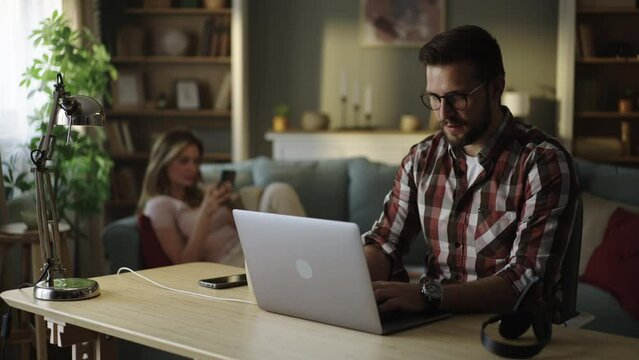 Handsome businessman manager working behind a laptop in a stylish home office. Remote work at home