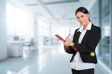 Happy professional business woman writing on clipboard