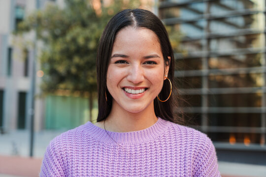 Close up individual portrait of a joyful and adorable teenage hispanic woman with friendly expression. Happy latin young female student looking at camera enjoying smiling with a perfect white teeth