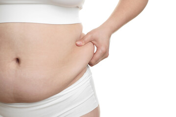 Naklejka premium Woman touching belly fat on white background, closeup. Overweight problem