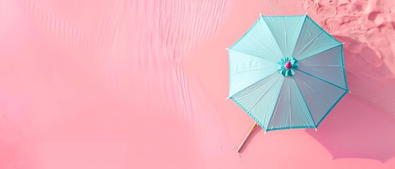 Top view of a blue beach umbrella on pink sand, creating a vibrant and tropical summer vibe. Perfect for travel and vacation themes.