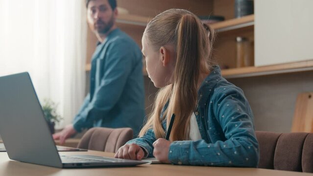 Happy family at home kitchen little daughter kid girl pupil schoolgirl study learning writing homework has problem with task difficult ask father for help dad helping school child with studies laptop