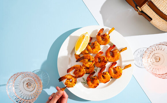 A Plate of BBQ Prawn Skewers in Summer Sun