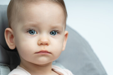 Close-up of a toddler baby gazing at the camera with calm face