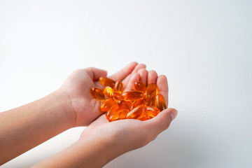 fingers holding a oil filled capsule, soft gel, food supplements, fish oil, omega 3 omega 9