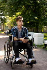 young disabled man in wheelchair walking park and listening music