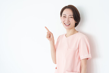 指差しする女性看護士（白背景・白バック）