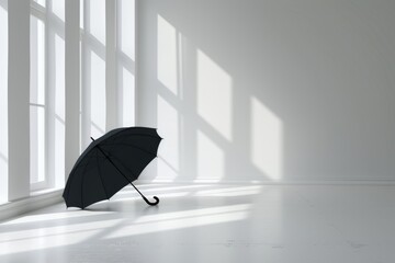 An open black umbrella lies on the floor in a bright room