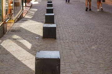 protective metal posts on the pavement separating the pedestrian part from the automobile part