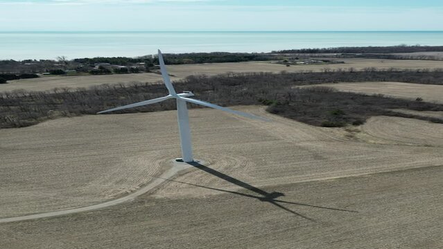 aerial view of a wind turbine in operation with the lake in the background
