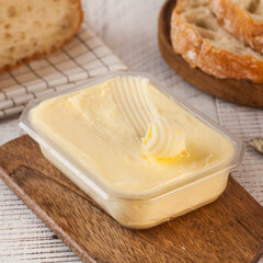 Fresh creamy butter in a container, perfect for cooking and spreading. 