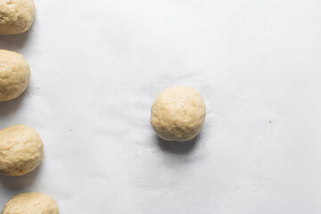 Overhead view of raw nigerian egg roll or egg wrapped in dough to make nigerian egg roll, process of making nigerian egg roll and small chops