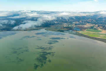 Aerial view of clouds over  agricultural fields and northern San Francisco Bay where it meets the...