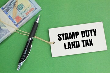 paper money, pens and tags with the words Stamp Duty Land Tax or the letters SDLT