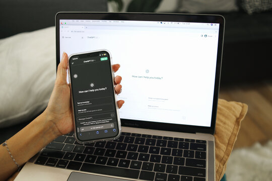 Application Of ChatGPT. Hand Using Smartphone And Laptop Display Chat Bot Screen