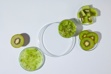 Obraz premium A glass tray in round shaped, decorated by a small dish of chopped kiwi in the corner, still has blank space for showing product has kiwi origin over white background. Displaying space, top view