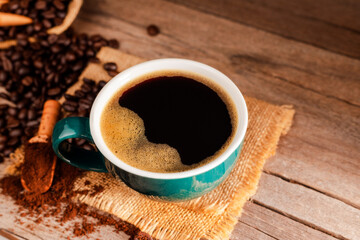 Black coffee with green cup and roasted coffee beans brown sugar and a cup of hot espresso coffee flat top view on a dark background